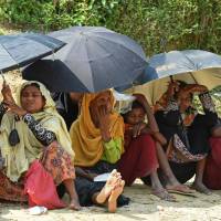 Rohingya Muslim refugees shelter from the sun under umbrellas as they wait for relief aid at the Kutupalong refugee camp in the Bangladeshi district of Ukhia on Wednesday. Myanmar and Bangladesh have agreed to work together to repatriate hundreds of thousands of Rohingya Muslim refugees, officials said, but details remain thin as the humanitarian crisis deepens. | AFP-JIJI