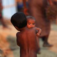 A Rohingya refugee child carries an infant at a refugee camp in Palang Khali near Cox\'s Bazar, Bangladesh, Wednesday. | REUTERS