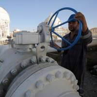 A worker checks pipelines at the Bai Hassan oil field, west of the northern Iraqi city of Kirkuk, on Thursday. | AFP-JIJI
