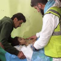 An unconscious Syrian child receives treatment at a hospital in Khan Sheikhun, a rebel-held town in the northwestern Syrian Idlib province, following a suspected toxic gas attack in April. The regime of Syrian President Bashar Assad was responsible for a deadly sarin gas attack on the rebel-held town in April, a U.N. report found on Thursday. | AFP-JIJI