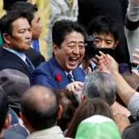 Prime Minister Shinzo Abe shakes hands with his supporters after an election campaign rally in Fukushima on Oct. 10. | REUTERS