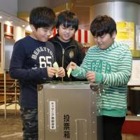Children cast ballots in a mock election Friday at the KidZania Tokyo career theme park in Koto Ward. | KYODO