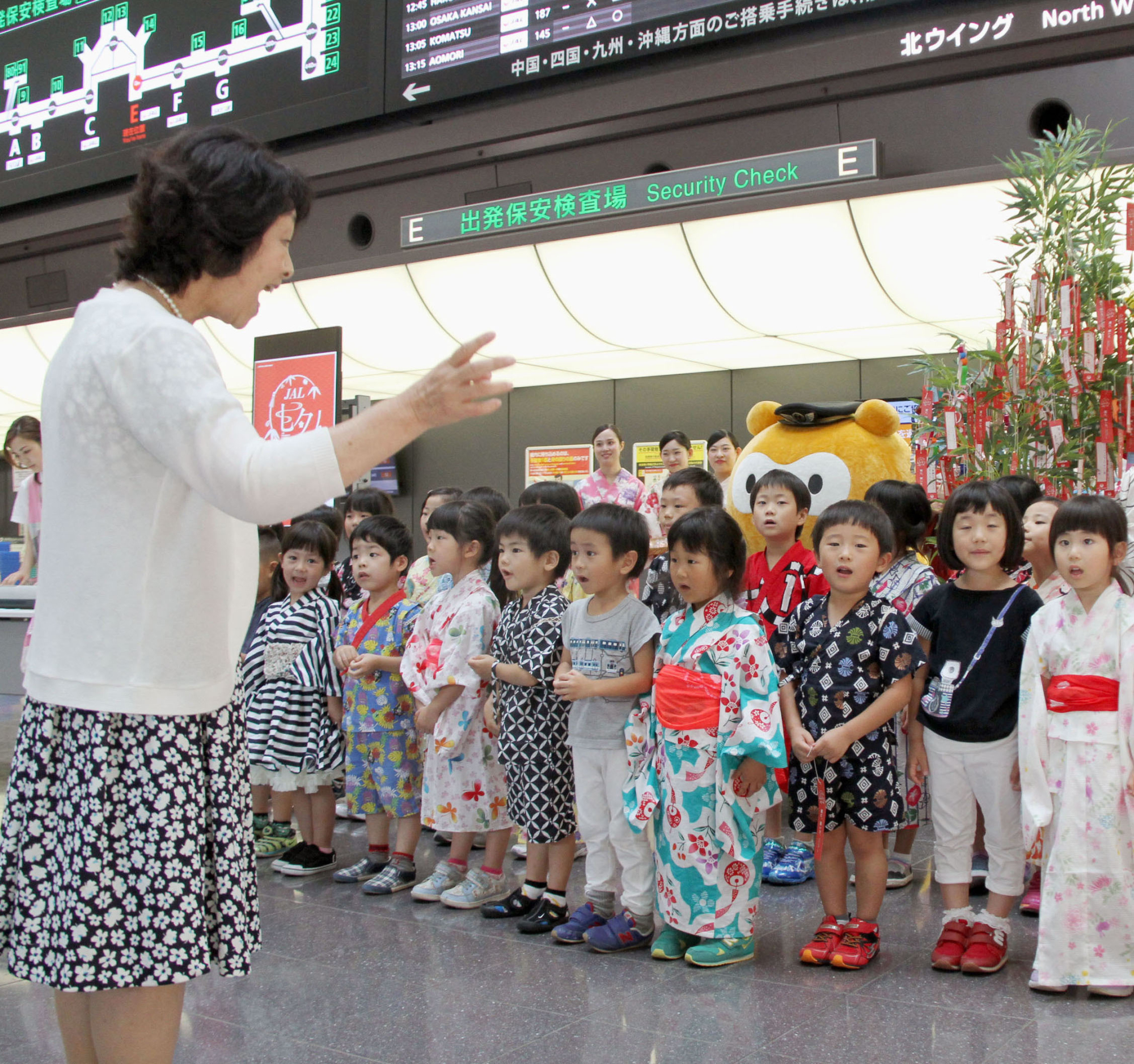 Children in a day care facility inside Haneda airport in Tokyo sing in the departure lobby of the international terminal in July. | KYODO