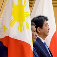Visiting Philippine President Rodrigo Duterte and Prime Minister Shinzo Abe review an honor guard during a welcome ceremony at Abe\'s official residence in Tokyo on Monday. | REUTERS