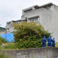 Police Friday conduct an investigation at an apartment in Hitachi, Ibaraki Prefecture, where a man allegedly set a fire and killed his wife and five children. | KYODO