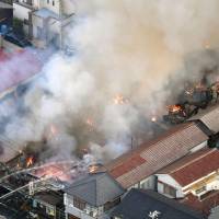 Firefighters battle to keep a blaze from burning down a shopping district in the city of Akashi, Hyogo Prefecture, on Wednesday. KYODO | AP