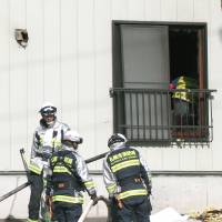 Firefighters work at the scene of an apartment fire in Sapporo on Thursday, in which two infants aged 2 and 3 died. | KYODO