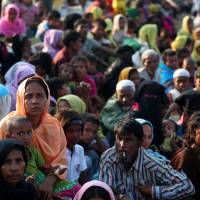 As they arrive in Teknaf, Bangladesh, on Oct. 25 after fleeing from Myanmar, Rohingya refugees wait to receive permission from the Bangladesh Army to continue their journey to a refugee camp. | REUTERS