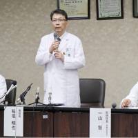 Nobuya Inagaki (center), the head of Kyoto University Hospital, apologizes after the death of a woman who is alleged to have died as a result of improperly mixed medicine from the facility, at a news conference in Kyoto on Tuesday. | KYODO