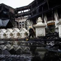 Firefighters work at the scene after a fire guts the Kandawgyi Palace hotel in Yangon on Thursday. | AFP-JIJI