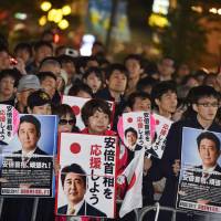 People listen to Prime Minister Shinzo Abe deliver a speech in Tokyo on Friday for Sunday\'s Lower House election. | AFP-JIJI