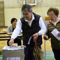 People cast ballots in the Lower House election at a polling station in Minato Ward, Tokyo, on Sunday. | SATOKO KAWASAKI