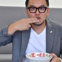 Toshiyuki Kiyomiya, president and chief operating officer of Chikaranomoto Holdings Co., the company that runs the Ippudo ramen chain, mimmicks eating a bowl of ramen on Sept. 29 in Tokyo\'s Ginza district. | YOSHIAKI MIURA