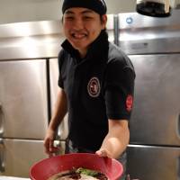Tetsuya Seki, chief manager at Ippudo’s Gotanda outlet in Tokyo, serves a bowl of ramen at his restaurant on Friday. | YOSHIAKI MIURA