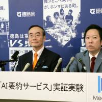 Tokushima Gov. Kamon Iizumi (left) and Media Do Holdings Co. President Yasushi Fujita announce Tuesday at the Tokushima Prefectural Government building the launch of an experiment to summarize the governor\'s news conferences using AI. | KYODO