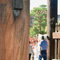 A column of a gate at Zenkoji Temple in Nagano Prefecture is seen vandalized with an \"X\" mark on Monday. | KYODO