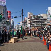 Members of Kibo no To (Party of Hope) rally the crowd during a campaign stop in Tokyo on Tuesday ahead of the Oct. 22 Lower House election. | BLOOMBERG