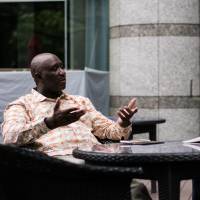 Kyoto Seika University President-elect Oussouby Sacko speaks with writer Baye McNeil in Tokyo. | NICHOLAS SEAGREAVES