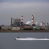 A jet ski passes a Kobe Steel plant in Kagogawa, Hyogo Prefecture, on Saturday. The steelmaker\'s scandal  is more proof that Japanese companies need better corporate governance. | BLOOMBERG