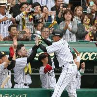 The Tigers\' Kosuke Fukudome is congratulated by teammates after hitting a two-run homer in the sixth inning against the BayStars on Saturday in Game 1 of the Central League Climax Series First Stage at Koshien Stadium. Hanshin beat Yokohama 2-0. | KYODO