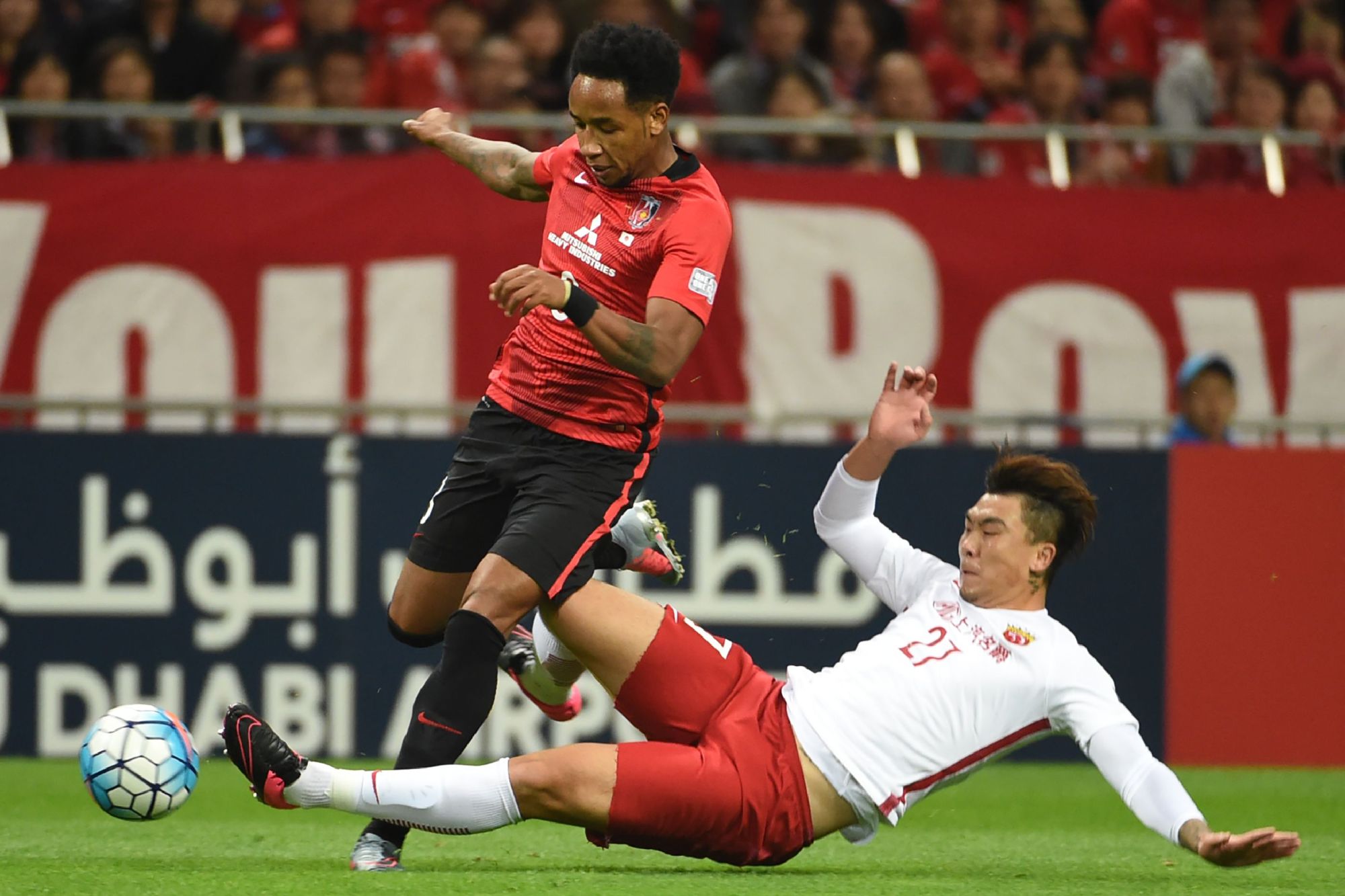 Urawa's Rafael Silva (left) and Shanghai's Shi Ke compete for the ball during the second leg of their Asian Champions League semifinal on Wednesday in Saitama. Reds won 1-0. | AFP-JIJI