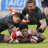 Japan\'s Ryuji Noguchi scores a first-half try against the World XV squad on Saturday in Fukuoka. The World XV defeated the Brave Blossoms 47-27. | KYODO