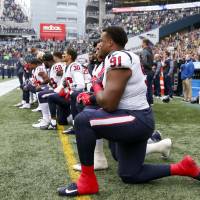 Houston Texans defensive tackle Carlos Watkins (91) and teammates kneel during the national anthem before kickoff against the Seattle Seahawks at CenturyLink Field in Seattle Sunday. | JOE NICHOLSON / VIA USA TODAY SPORTS
