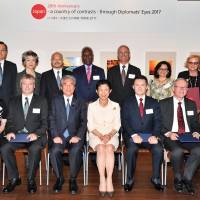 Attendees at the “Japan Through Diplomats’ Eyes 2017” opening event at Roppongi Hills on Oct. 3. Front row, left to right: Luxembourg Ambassador Beatrice Kirsch, Executive Committee chair; Grand prize winner Attila Erdos; Hirofumi Nakasone, head of the jury; Honorary President Princess Takamado; Princess Takamado Memorial prize winner Andrey Kuzhabekov; New Zealand Ambassador Stephen Payton, winner of the Ambassador Prize; and Macedonian Ambassador Andrijana Cvetkovik, who received a special mention from the jury. Behind them are other special-mention winners and committee members. | YOSHIAKI MIURA