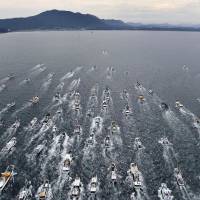 A fleet of fishing boats sails in the Genkai Sea on Sunday off  Munakata, Fukuoka Prefecture, during the Miare Festival to pray for the safety of seafaring vessels and for a good catch. | KYODO