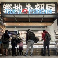 Customers inspect the offerings at Tsukiji Fishroom in Newark Airport\'s Terminal C. | BLOOMBERG