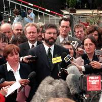 shows Sinn Fein leader Gerry Adams (center, with beard) and Martin McGuinness (behind Adams) arrive at the historic first session of the newly elected Northern Ireland Assembly at Stormont Castle in Belfast on July 1, 1998. | AFP-JIJI