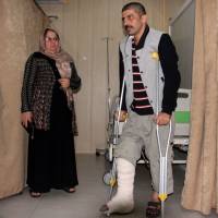An earthquake victim is helped at Sulaimaniyah Hospital on Sunday in Sulaymaniyah, Iraq. | AFP-JIJI