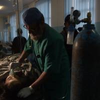 An Afghan journalist is treated at a hospital after a sucide attack outside a wedding hall in Kabul on Thursday. The attacker blew himself up outside the wedding hall, killing at least nine people in an apparent attempt to strike a political gathering underway inside. | AFP-JIJI