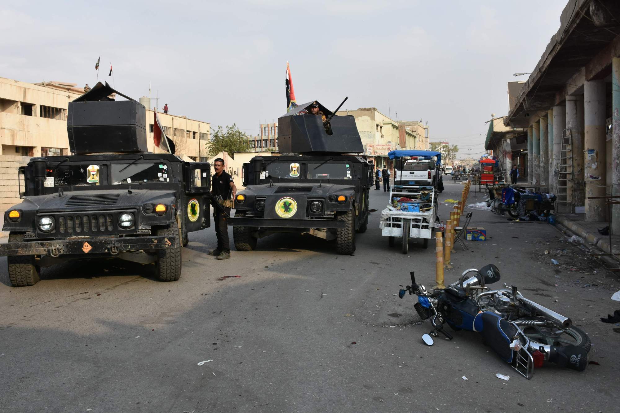 Iraqi security forces inspect the scene of a twin suicide attack at a shopping area in Iraq's disputed Kirkuk city on Sunday. The attackers struck near a former police station used by Saraya al-Salam, a Shiite paramilitary force led by powerful Shiite cleric Moqtada al-Sadr, the official said on condition of anonymity. | AFP-JIJI