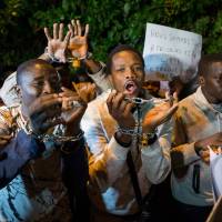 Protesters, some from sub-Saharan African nations, shout slogans during a demonstraion against \"Slavery in Libya\" on Thursday outside the Libyan Embassy in the Moroccan capital of Rabat. | AFP-JIJI