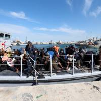 Migrants arrive at a naval base after they were rescued by Libyan coastal guards in Tripoli Thursday. | REUTERS