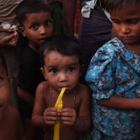 Rohingya refugees stand inside the Kutupalong refugee camp in the Bangladehsi distrcit of Ukhia on Friday. | AFP-JIJI