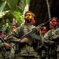 Guerrillas of the New People\'s Army, the Maoist armed wing of the Communist Party of the Philippines, stand in formation in the Sierra Madre mountain range east of Manila on July 30. | AFP-JIJI