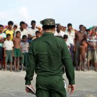 Rohingya Muslims wait to cross the border to Bangladesh, in a temporary camp outside Maungdaw, northern Rakhine state, Myanmar, Sunday. | REUTERS