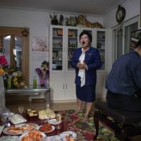 Eyeglass shop manager Song Song-Hui sings for her family members in her apartment in Pyongyang on Nov. 17. | AFP-JIJI