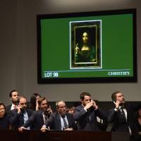 Christie\'s employees take bids for Leonardo da Vinci\'s \"Salvator Mundi\" during the Post-War &amp; Contemporary Art Evening Sale at Christie\'s New York November 15, 2017. | AFP PHOTO / TIMOTHY A. CLARY