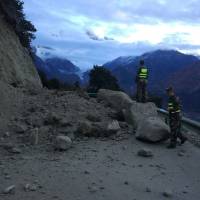 Rescuers look at a road blocked by fallen rocks near the town of Paizhen in southwestern China\'s Tibet Autonomous Region on Saturday after a strong earthquake shook the area. | AP
