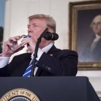 U.S. President Donald Trump drinks water from a bottle as he delivers remarks on Wednesday in the Diplomatic Room at the White House in Washington. | AFP-JIJI