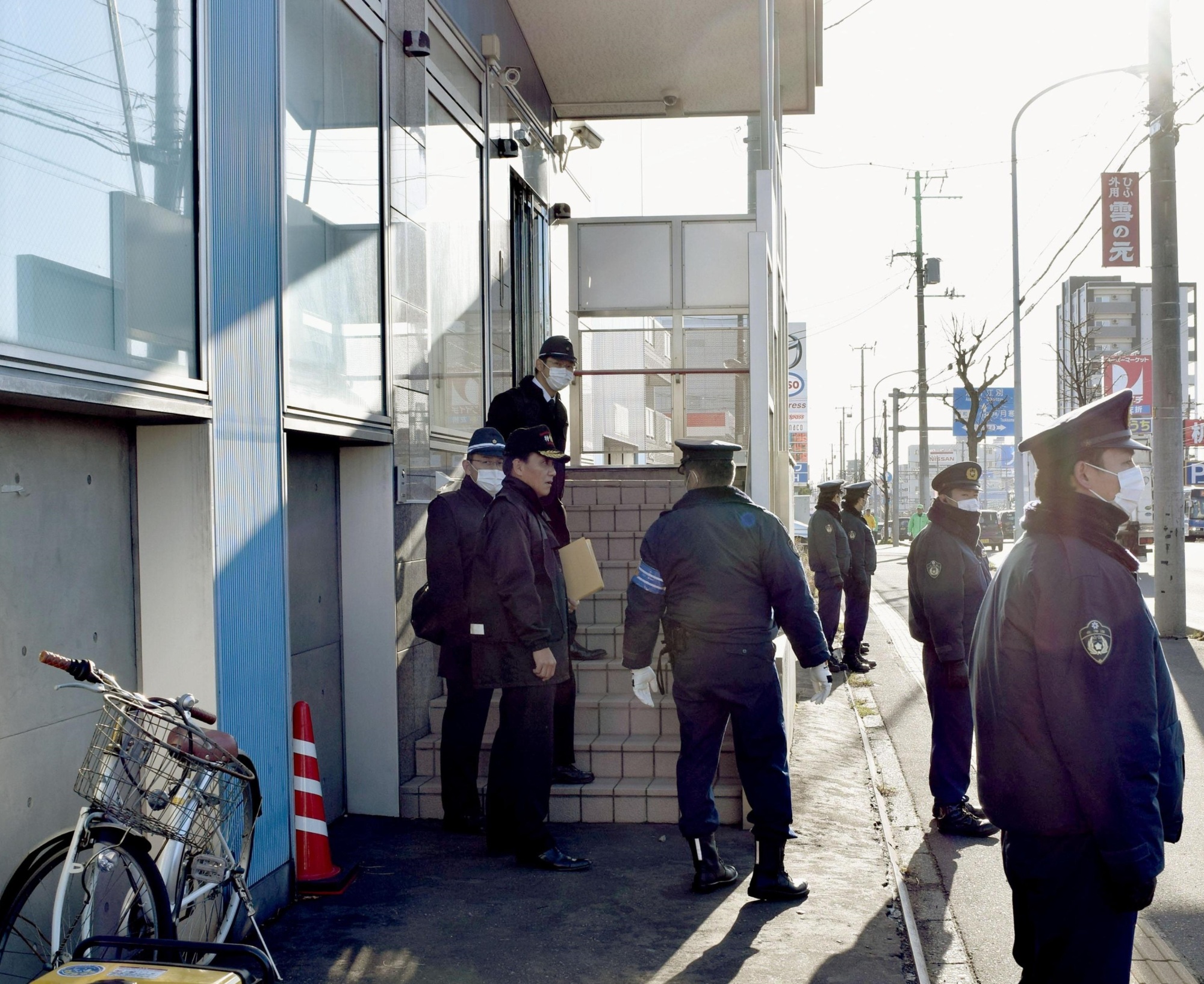 Police officers stand guard during a search of a facility believed to be used by the Aum Shinrikyo successor group Aleph in Sapporo on Monday. | KYODO