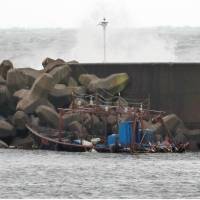 A fishing boat that washed ashore with eight North Korean men aboard is seen Friday in Yurihonjo, Akita Prefecture. The boat, which disappeared on Saturday, has been found on the seabed. | KYODO