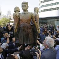 People move in for a closer look at a \"Comfort Women\" monument after its unveiling in San Francisco on Sept. 22. On Friday, the South Korean parliament passed a bill to officially designate Aug. 14 as the day to commemorate the Korean women who were forced into wartime brothels for the Japanese military. | AP