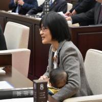 Yuka Ogata, a Kumamoto city lawmaker, is seen bringing her 7-month-old baby son to assembly meeting last week. | KYODO
