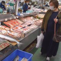 A shopper glances at salmon at a fish market in Kushiro, Hokkaido, on Nov. 9. | KYODO