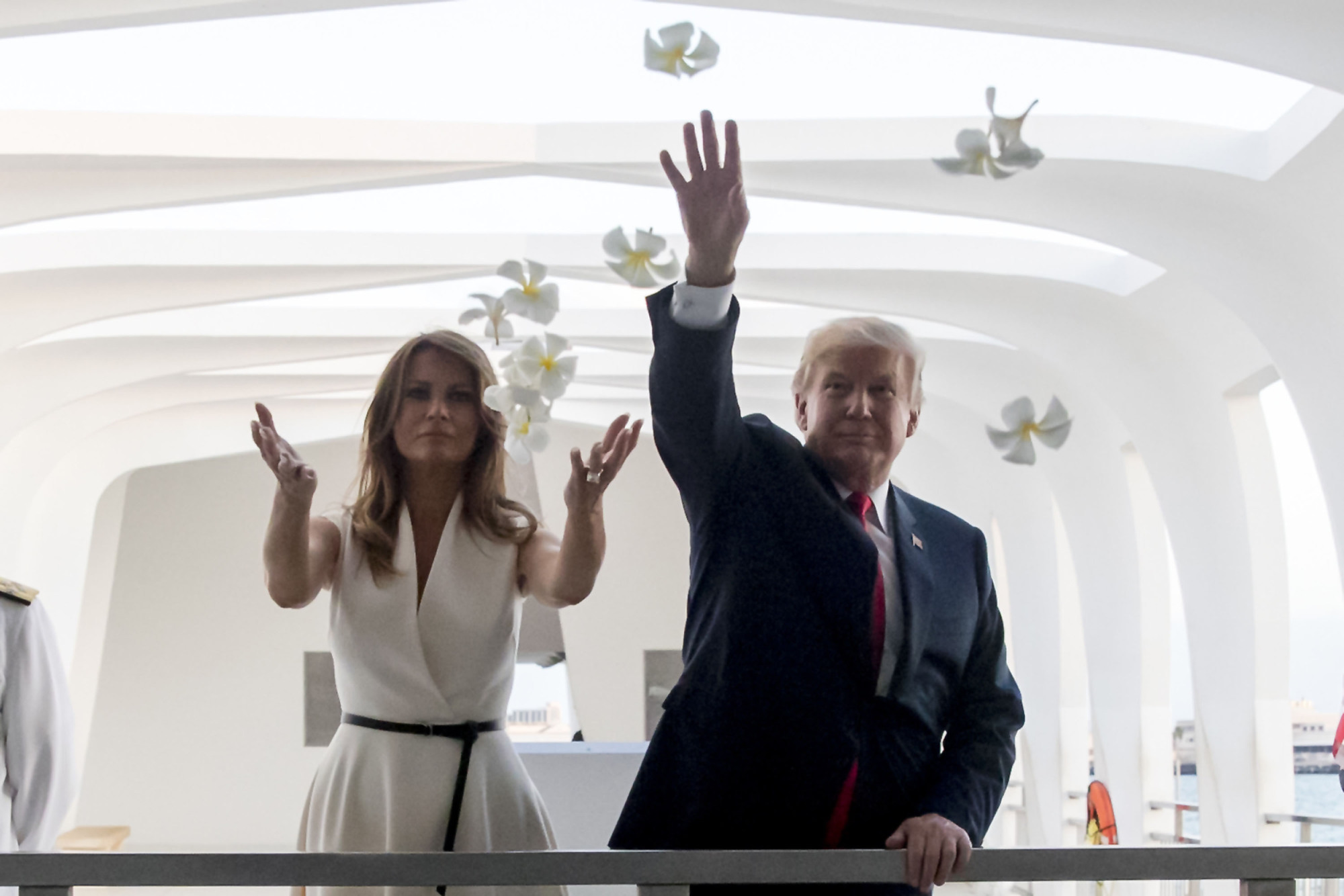 U.S. President Donald Trump and first lady Melania throw plumeria flower petals while visiting the Pearl Harbor Memorial in Honolulu on Friday. | AP