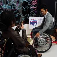 A man tries out a wheelchair that can also move sideways at Super Welfare Expo on Nov. 10 in Tokyo\'s Shibuya Ward. | MAGDALENA OSUMI